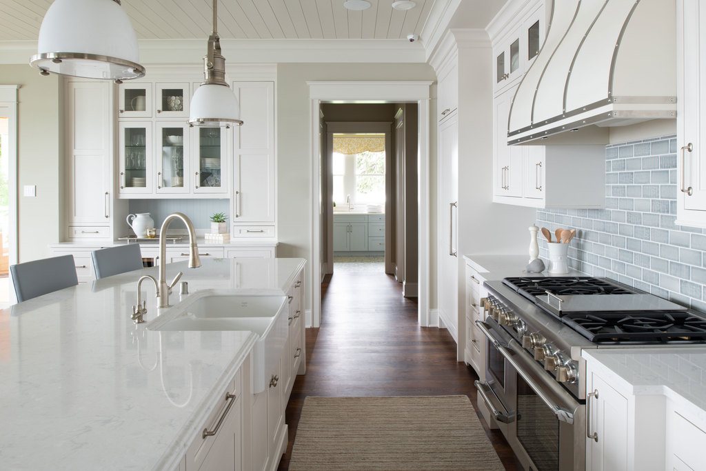 White kitchen designed by Studio M featuring custom cabinetry.