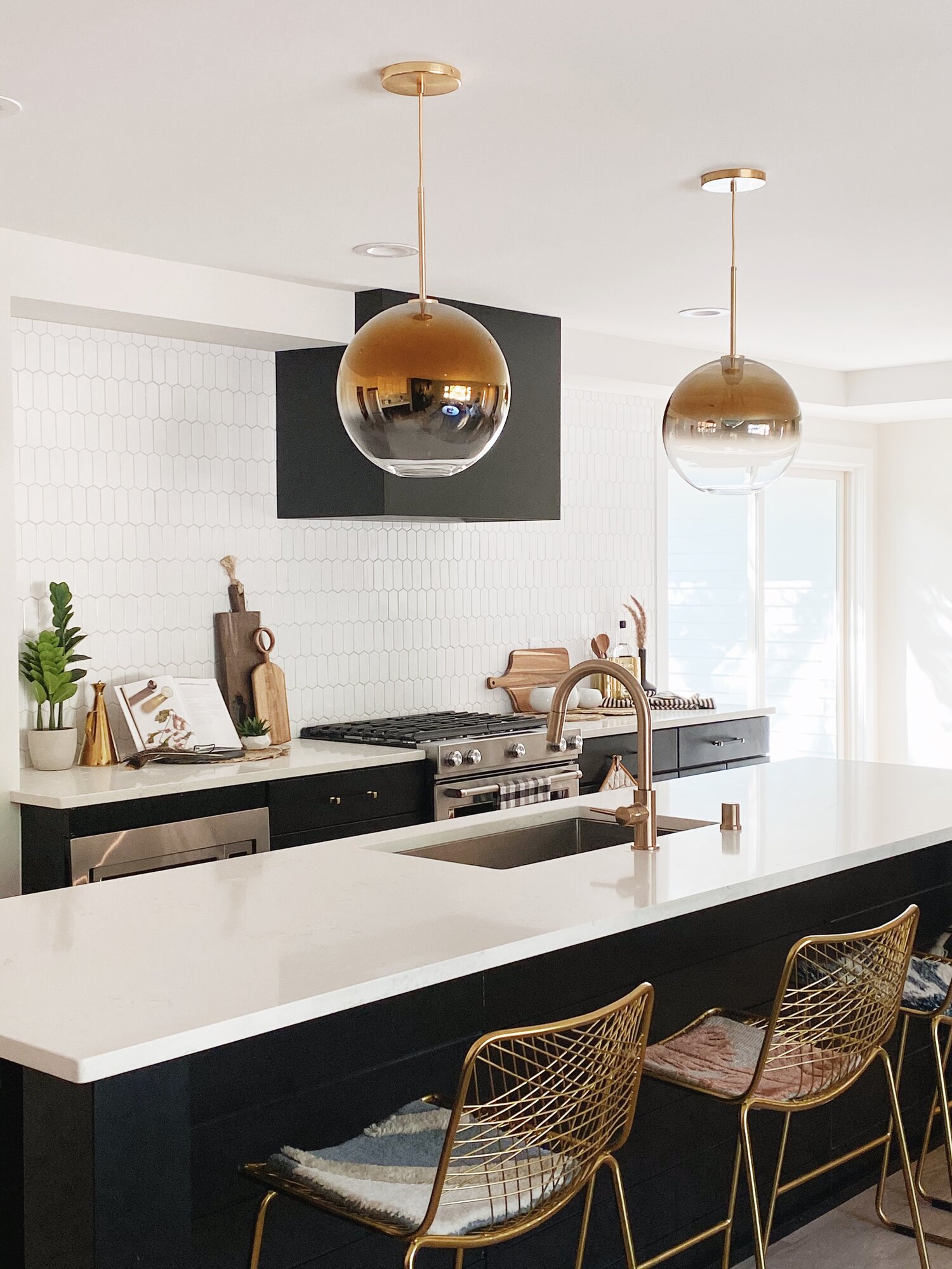Modern kitchen featuring gold light pendants