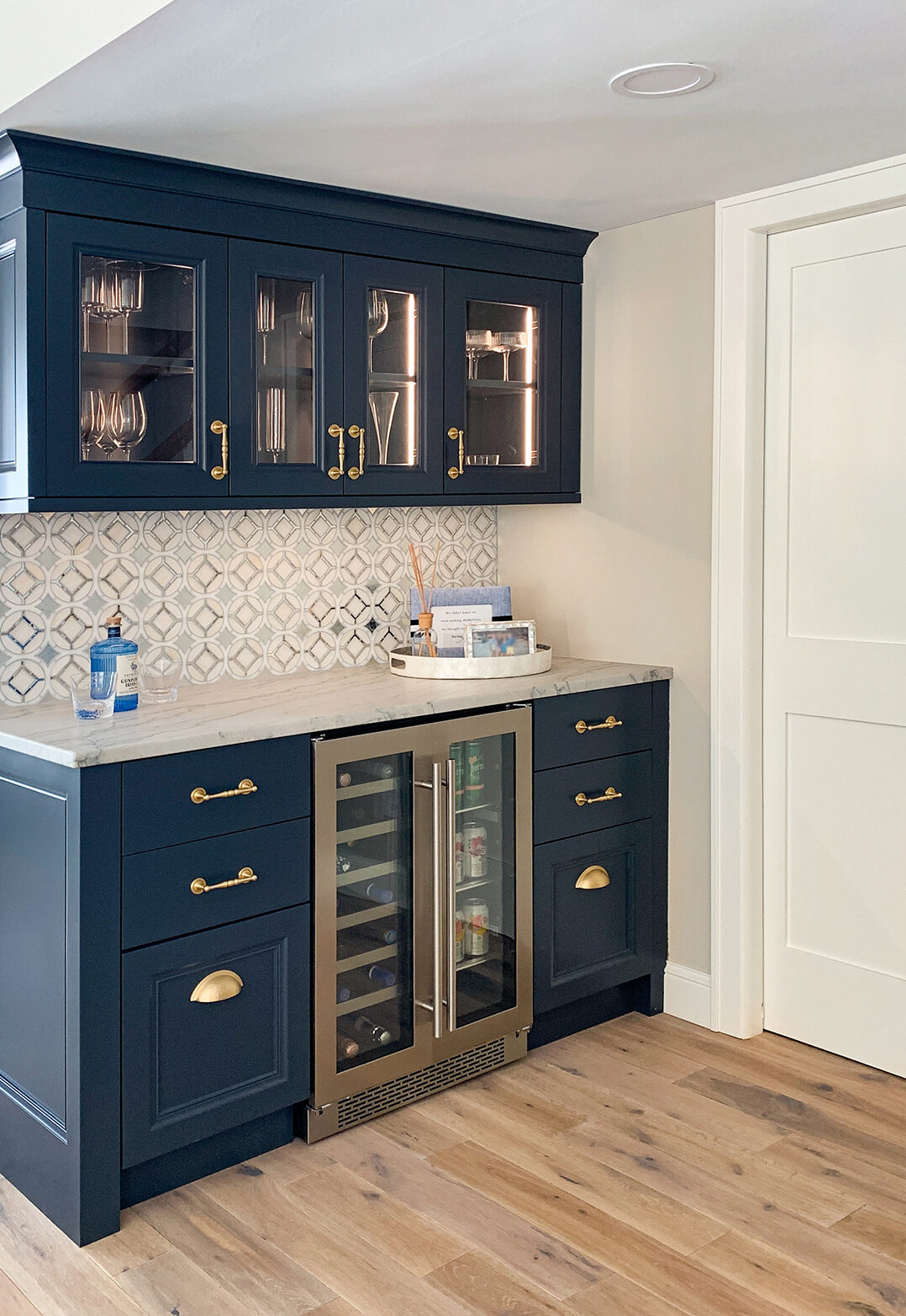 Blue dry bar with integrated lighting and under-cabinet wine refrigerator