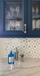 Blue dry bar with mirrored tile backsplash and cool marble countertop
